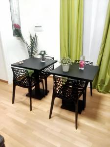 two black tables and chairs in a room with green curtains at 5 bedrooms apartement at Napoli 500 m away from the beach with sea view and wifi in Naples