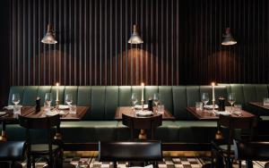 a dining room with tables and chairs and lights at TORTUE Hamburg in Hamburg