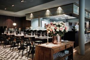 a dining room with tables and chairs and flowers at TORTUE Hamburg in Hamburg