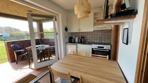 een keuken en eetkamer met een tafel en stoelen bij Søndervig Camping & Cottages in Søndervig