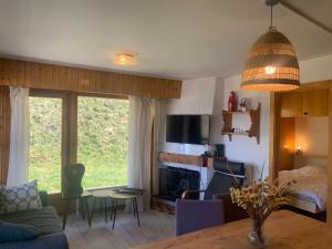 een woonkamer met een bank en een tafel met een open haard bij Mont Rouge VIEW & CENTER apartments by Alpvision Résidences in Veysonnaz