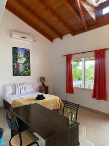 Hotel Puerto Libertad - Iguazú في Puerto Libertad: غرفة نوم بسرير وطاولة ونافذة