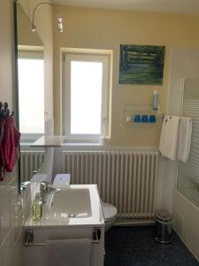 łazienka z umywalką, toaletą i oknem w obiekcie Villa Hébert w Saint-Malo