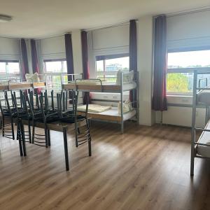 Low Budget Hostel في ميونخ: غرفة بها العديد من الأسرّة ذات الطابقين وطاولة وكراسي