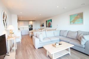 a living room with a couch and a table at Coastal apartment sea views in Saint Merryn