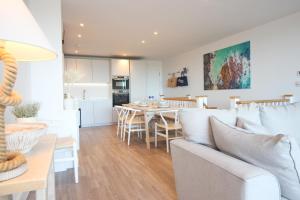 a living room and dining room with a couch and a table at Coastal apartment sea views in Saint Merryn