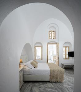 ein weißes Schlafzimmer mit einem Bett und zwei Spiegeln in der Unterkunft MyBoZer Hotel Kallisto in Imerovigli