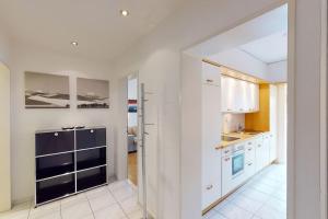 a kitchen with white cabinets and a blue refrigerator at Executive 1 bedroom flat, city center (Hammer 1) in Zürich