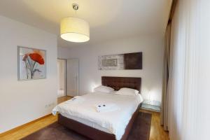 a bedroom with a large bed with white sheets at Executive 1 bedroom flat, city center (Hammer 1) in Zürich