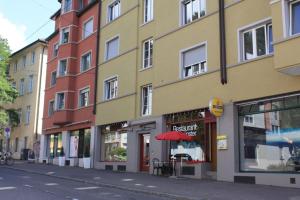 a building with a red umbrella on a city street at Executive 1 bedroom flat, city center (Hammer 1) in Zürich