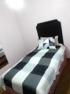 a bedroom with a black and white bed with pillows at M&T Guesthouse in Orkney