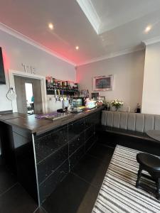 a bar in a room with a counter and a chair at Tudor Rose Hotel in Blackpool