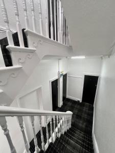 a staircase with white railings in a house at Tudor Rose Hotel in Blackpool