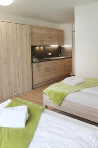 two beds in a room with wooden cabinets at Hotel am Wittelsbacher Markt by greenpartment in Langquaid