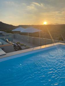 una piscina con il tramonto sullo sfondo di Yellow Hill Penthouse a Żebbuġ