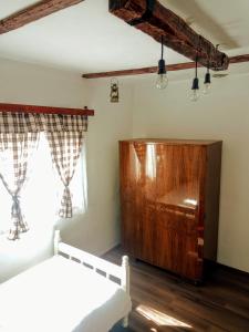 1 dormitorio con 2 camas y armario de madera en Kuća iz zavičaja, en Kuršumlija