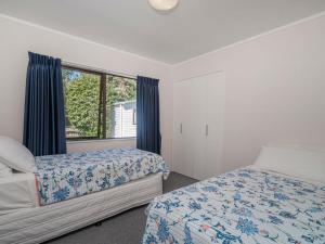 - une chambre avec 2 lits et une fenêtre dans l'établissement Seashells Bach - Whangamatā Holiday Home, à Whangamata