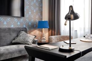 a living room with a couch and a table with a lamp at TORTUE Hamburg in Hamburg