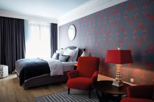 a bedroom with a bed and a red chair at TORTUE Hamburg in Hamburg