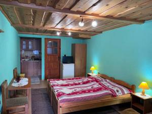 a bedroom with a large bed and a kitchen at Penzión Janka in Zuberec