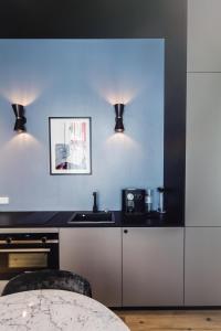 a kitchen with a table and two lights at TORTUE Hamburg in Hamburg