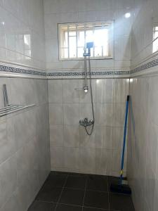 a bathroom with a shower with a mop and a window at Luxueus appartement Wanica, Welgedacht C in Wanica +19 photos