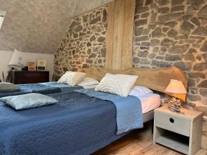 2 Betten in einem Zimmer mit einer Steinmauer in der Unterkunft 310 -Maison de charme 8personnes proche des plages in Frehel