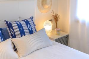 a bed with blue and white pillows and a lamp at Flateli La Fosca in Palamós