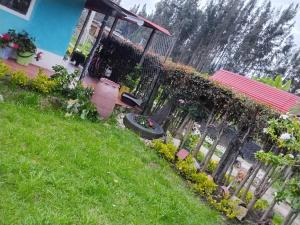 a garden with flowers and a fence in front of a house at Casa Campestre Adela in Suesca