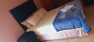 a bed with a blue blanket on top of it at M&T Guesthouse in Orkney