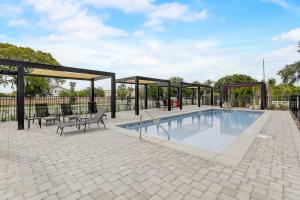 a swimming pool with a pavilion and benches next to it at Kissimmee Modern 3BR Home With a pool & Close to Beach in Kissimmee