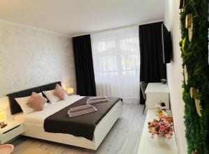 a bedroom with a bed and a large window at Sara room in Curtea de Argeş