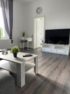 sala de estar con mesa y TV grande en Apartments im Herzen von Velbert, en Velbert