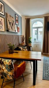 een woonkamer met een houten tafel en stoelen bij Noy´z in der belebten Neustadt in Dresden