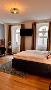 een slaapkamer met een groot bed en 2 ramen bij Noy´z in der belebten Neustadt in Dresden