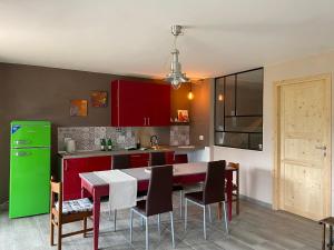 uma cozinha com uma mesa e um frigorífico verde em SUNRISE HILL B&B em Menestrello