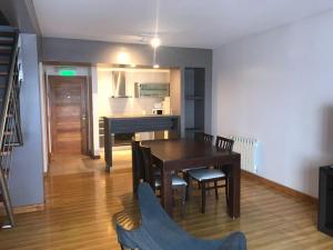 a dining room with a table and a piano at Polo Sur Apartamentos in Ushuaia