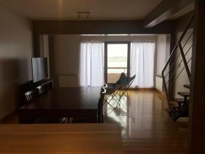 uma sala de jantar com uma mesa e cadeiras e uma janela em Polo Sur Apartamentos em Ushuaia