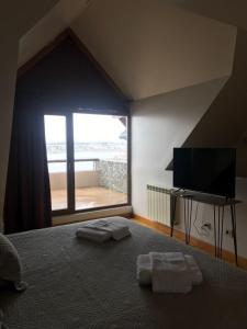 a bedroom with a bed with two towels on it at Polo Sur Apartamentos in Ushuaia +48 photos
