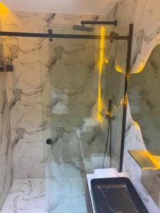 a bathroom with a shower with a glass door at PROOF RESIDENCE in Lekki
