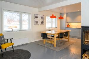 Gimsøy的住宿－Lillevik Lofoten，厨房以及带木桌和椅子的用餐室。