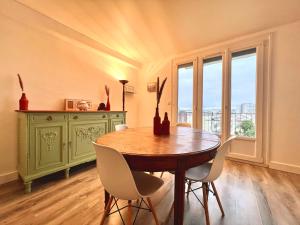 a dining room with a wooden table and chairs at Appartement proche gare, 6 voyageurs et stationnement gratuit in Reims
