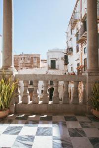 einen Balkon mit Säulen und einem karierten Boden in der Unterkunft B&B Palazzo Corvino in Palermo