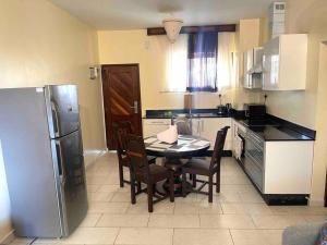 a kitchen with a table and chairs and a refrigerator at Golden Beachfront Apartment Diani in Ukunda