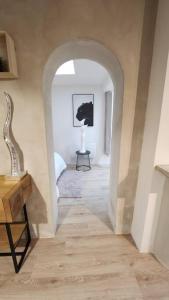 a hallway with an archway with a table in a room at La Tanière Lens est in Sallaumines