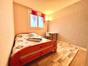 a bedroom with a bed with a wooden floor at Appartement proche gare, 6 voyageurs et stationnement gratuit in Reims