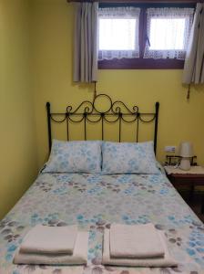 ein Schlafzimmer mit einem Bett, auf dem zwei Handtücher liegen in der Unterkunft Apartamento Rural in Cangas de Onís