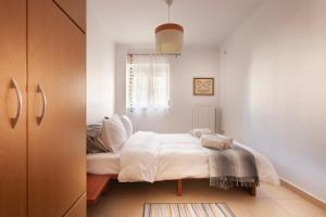 a bedroom with a bed with white sheets and a window at Spartan Gem Apartment in Sparta