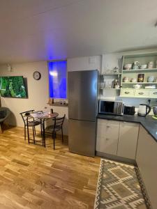 a kitchen with a table and a stainless steel refrigerator at Cozy Haven in Klaksvík