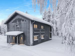 una cabaña de madera en la nieve con árboles nevados en Holiday Home Levin hiihtäjä by Interhome, en Sirkka